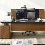 Kompleksowa aranżacja biura: drewniane biurko, ergonomiczny fotel, szafa w jasnym, nowoczesnym wnętrzu