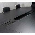 Projekt stołu konferencyjnego z wbudowanymi panelami zasilania dla ergonomicznych przestrzeni biurowych.