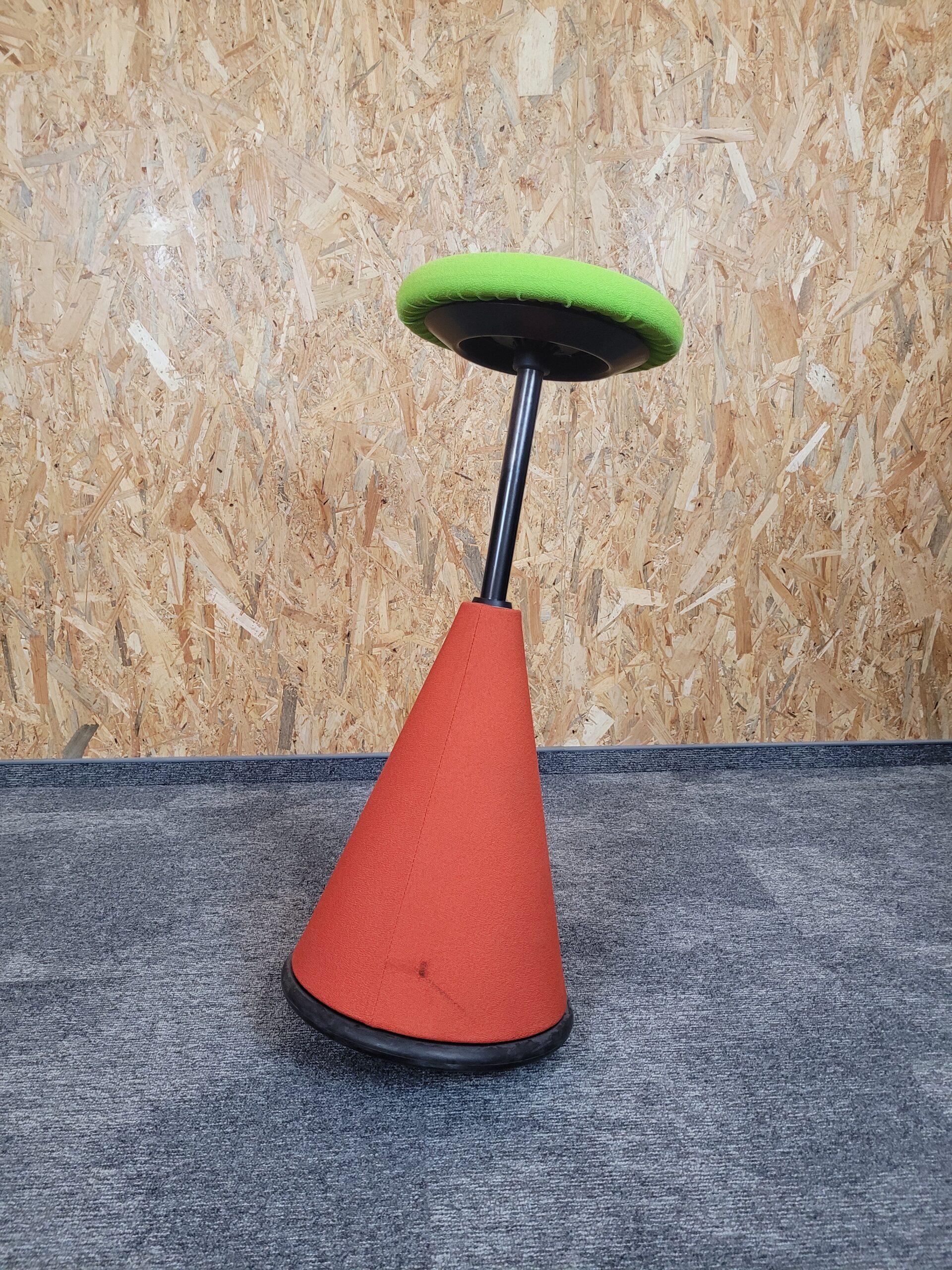 Ergonomiczny stołek do biura z zielonym siedziskiem i pomarańczową podstawą.