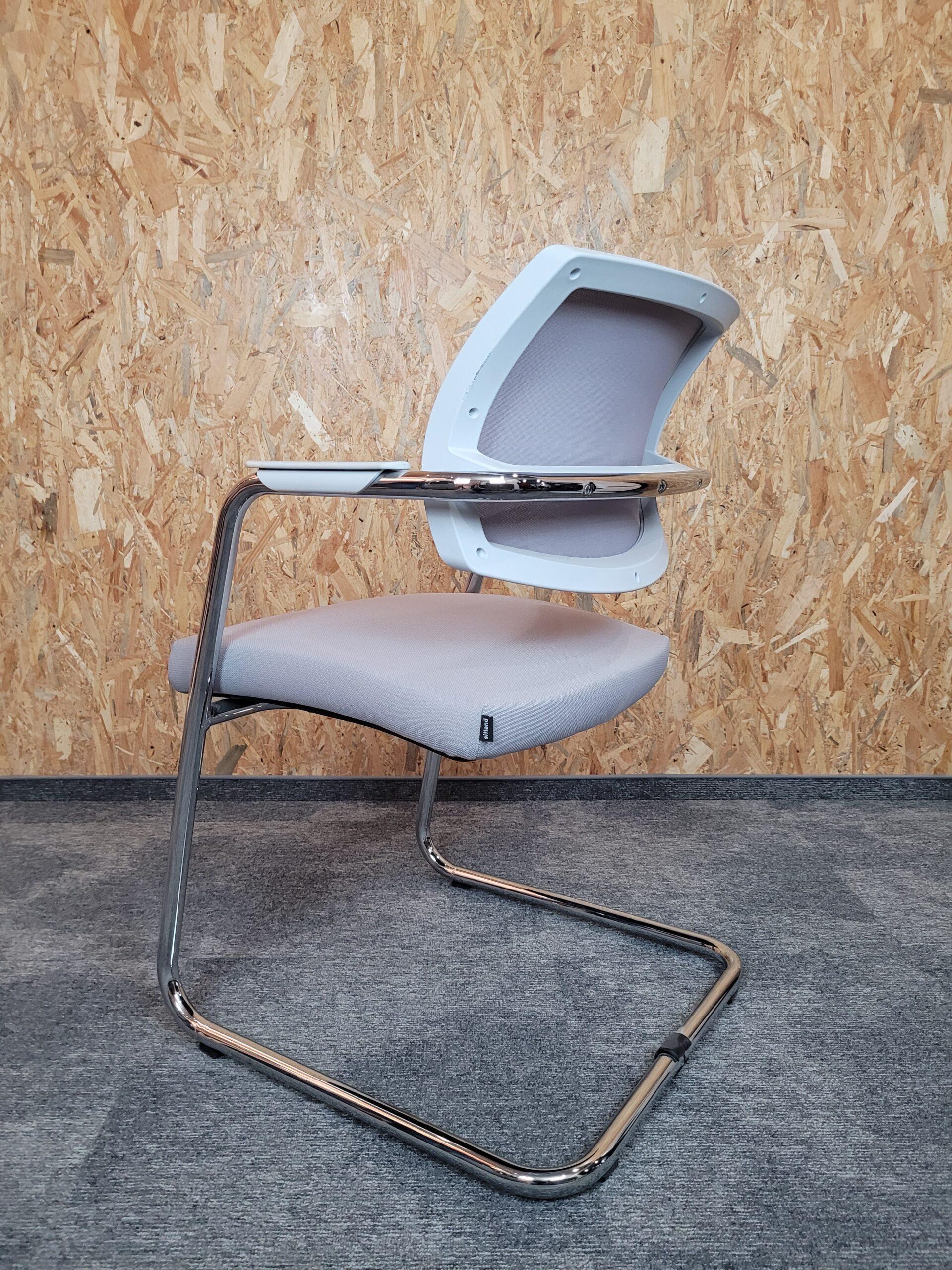 Jasnoszary fotel biurowy z chromowaną ramą przeznaczony do ergonomicznych przestrzeni pracy.