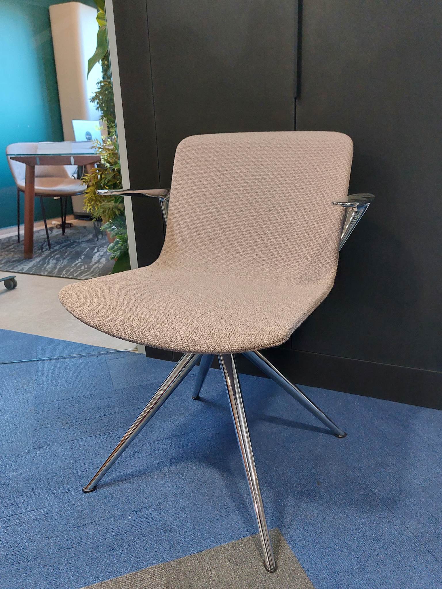 Designerskie krzesło biurowe z beżową tapicerką i chromowanymi nogami, idealne do nowoczesnych przestrzeni.
