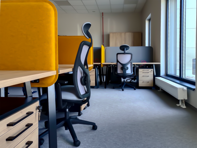 Funkcjonalna przestrzeń biurowa z ergonomicznymi stanowiskami, jasnymi biurkami i żółtymi panelami akustycznymi.