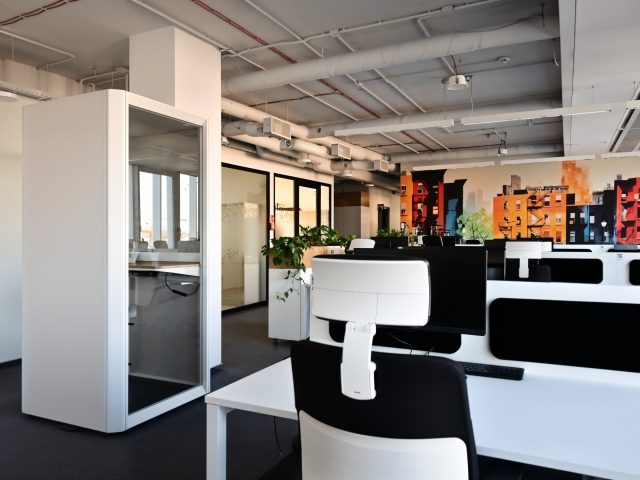 Projekt biura LOGAN: ergonomiczny open space z białymi stanowiskami i kabiną akustyczną.